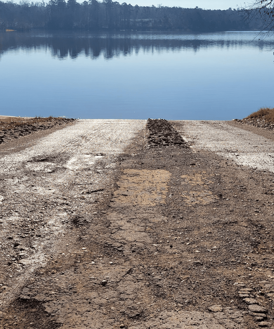Dirt road leading to calm lake